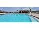 Sparkling community pool with lounge chairs and covered pavilion surrounded by lush landscaping at 265 Meadowbrook Blvd, Winter Haven, FL 33881