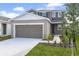Charming two-story home featuring a gray-brown exterior, a two-car garage, and fresh landscaping at 6381 Clover St, Lake Hamilton, FL 33851