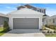 Exterior of home featuring a two-car garage, landscaping and neutral color scheme at 6393 Clover St, Lake Hamilton, FL 33851