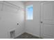 Bright laundry room with tiled flooring, a utility sink, and modern appliances at 6393 Clover St, Lake Hamilton, FL 33851