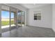 Bright living room featuring sliding glass doors, neutral paint and grey tiled floor at 6393 Clover St, Lake Hamilton, FL 33851