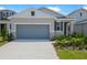 Single-Gathering home with a gray garage door, light stone details, and well-maintained landscaping at 6397 Clover St, Lake Hamilton, FL 33851
