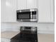 Close-up of stainless steel microwave and electric cooktop, blending style and functionality at 6397 Clover St, Lake Hamilton, FL 33851