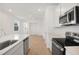 Bright kitchen featuring stainless steel appliances, a center island with a sink, and wood-look floors at 6397 Clover St, Lake Hamilton, FL 33851