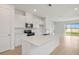Open kitchen with quartz countertops, a central island, stainless steel appliances, and sliding glass doors at 6397 Clover St, Lake Hamilton, FL 33851