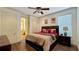 Cozy bedroom with hardwood floors, a ceiling fan, and a view to the bathroom at 1251 Radiant St, Reunion, FL 34747