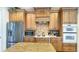 Well-equipped kitchen with stainless steel appliances, custom cabinets, and tile backsplash at 1251 Radiant St, Reunion, FL 34747