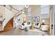 Bright living room with high ceilings and staircase has modern decor, a white sofa, and tiled flooring at 1251 Radiant St, Reunion, FL 34747