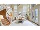 Light-filled living room with staircase features high ceilings, large windows, and a neutral sofa with wood accents at 1251 Radiant St, Reunion, FL 34747