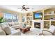 Cozy living room features a fireplace, built-in shelves, large windows, and a comfortable white sofa at 1251 Radiant St, Reunion, FL 34747
