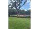 A community tennis court surrounded by lush greenery and an overhanging tree, perfect for outdoor activities at 1907 Partin Terrace Rd, Kissimmee, FL 34744