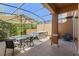 Covered patio featuring a dining table, chairs, and a jacuzzi surrounded by landscaping at 2618 Roadster Ln, Kissimmee, FL 34746
