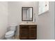 Cozy half bathroom with a dark wood vanity, neutral walls, and a rectangular mirror at 2618 Roadster Ln, Kissimmee, FL 34746