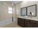 Bathroom features a tub/shower combo with glass doors, and double sink with dark cabinetry at 2618 Roadster Ln, Kissimmee, FL 34746