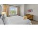 Bright bedroom with a large window, neutral walls, a wooden dresser and a comfortable bed at 2618 Roadster Ln, Kissimmee, FL 34746