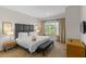 Cozy bedroom with a padded headboard, side table and bench plus a window with a view at 2618 Roadster Ln, Kissimmee, FL 34746