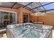 A hot tub under a screened-in patio overlooking the backyard at 2618 Roadster Ln, Kissimmee, FL 34746