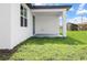 A covered back porch and a large, lush green yard provides a relaxing outdoor space at 308 Miami Ln, Kissimmee, FL 34759