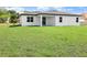 View of the house featuring a lush green backyard, perfect for outdoor activities and relaxation at 308 Miami Ln, Kissimmee, FL 34759
