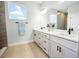 Bright bathroom with dual sinks, quartz countertop, wood look tile shower, and natural light at 308 Miami Ln, Kissimmee, FL 34759
