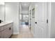Hallway view with bathroom vanity with quartz countertop and bedroom with natural light at 308 Miami Ln, Kissimmee, FL 34759