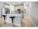 Open kitchen with stainless steel appliances, an island with bar stools, and adjacent living spaces at 308 Miami Ln, Kissimmee, FL 34759