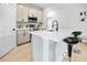 Well-lit kitchen with stainless steel appliances, quartz countertops, and an island with bar seating at 308 Miami Ln, Kissimmee, FL 34759