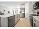Modern kitchen featuring stainless steel appliances, an island with a sink, and a view of the living area at 308 Miami Ln, Kissimmee, FL 34759