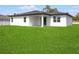 Home with a covered patio area and a spacious backyard with lush grass at 370 Marion Oaks Crse, Ocala, FL 34473