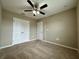 Comfortable bedroom showcasing a ceiling fan, plush carpet, and ample natural light at 4710 Nathan Hale Blvd, St Cloud, FL 34769
