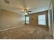 Cozy bedroom featuring two windows, plush carpet, and ceiling fan at 4710 Nathan Hale Blvd, St Cloud, FL 34769