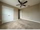 Neutral bedroom featuring plush carpet, ceiling fan, and large closet doors at 4710 Nathan Hale Blvd, St Cloud, FL 34769