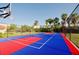 Outdoor basketball court showcasing a vibrant blue and red surface, enclosed by a chain-link fence for recreational fun at 5012 Shoreway Loop # 205, Orlando, FL 32819