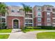 Beautiful condo building featuring a gated entry, lush landscaping, and classic architectural design with a pink exterior at 5012 Shoreway Loop # 205, Orlando, FL 32819