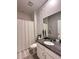 Bathroom features granite vanity, gray decorative wall, and shower with curtain at 9083 Coral Cape St, Kissimmee, FL 34747