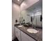 Bathroom vanity with granite countertops, double sinks, and a large mirror at 9083 Coral Cape St, Kissimmee, FL 34747