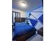 A modern bedroom design with a striking blue accent wall and stylish furnishings at 9083 Coral Cape St, Kissimmee, FL 34747