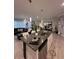 Open layout showcasing a stylish kitchen island, stainless steel appliances, and a view into the living and dining areas at 9083 Coral Cape St, Kissimmee, FL 34747