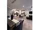 Open floor plan featuring a dining table, kitchen with island, and living area with large TV at 9083 Coral Cape St, Kissimmee, FL 34747