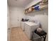 Practical laundry room featuring a side by side washer and dryer, tile flooring, and overhead shelving at , Kissimmee, FL 34744