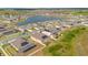 Scenic aerial view of community featuring stunning lake and multiple houses with solar panels at 109 Pineywoods St, St Cloud, FL 34772