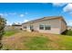 Backyard featuring a lawn, patio, and the exterior of the home under a blue sky at 109 Pineywoods St, St Cloud, FL 34772