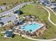 Aerial view of a pristine community pool with lounge seating, a splash area, and lush landscaping in a Gathering-friendly neighborhood at 109 Pineywoods St, St Cloud, FL 34772