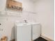 Functional laundry area with a full-size washer and dryer, and practical shelving at 109 Pineywoods St, St Cloud, FL 34772