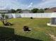 Large backyard enclosed by a white vinyl fence, with green grass and landscaping at 2991 Saint Clair St, Kissimmee, FL 34746