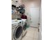 Laundry room with front loading washer and dryer, wire shelving, and tiled floor at 2991 Saint Clair St, Kissimmee, FL 34746
