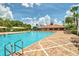 Outdoor pool with brick surround, clubhouse, lounge chairs, palm trees, and clear blue skies at 3341 Rodrick Cir, Orlando, FL 32824