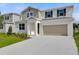 Inviting two-story home featuring a neutral color palette, a two-car garage, and a well-manicured lawn at 1743 Carnelian St, Deland, FL 32720