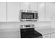 Contemporary kitchen with white cabinets, quartz countertops, and modern stainless steel appliances at 1743 Carnelian St, Deland, FL 32720