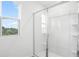 A bright bathroom featuring a clear glass shower and window, creating an airy atmosphere at 1743 Carnelian St, Deland, FL 32720